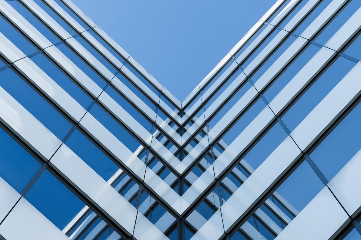 Fachada de edificio corporativo moderno con líneas geométricas de cristal